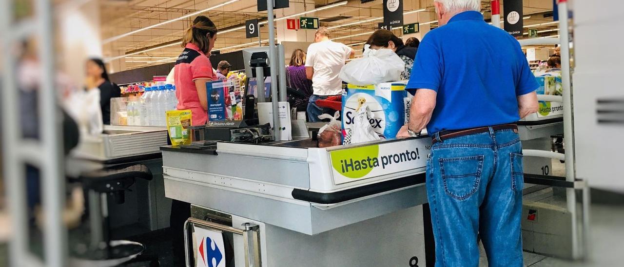 Una cajera de un supermercado de Canarias atiende a los clientes.