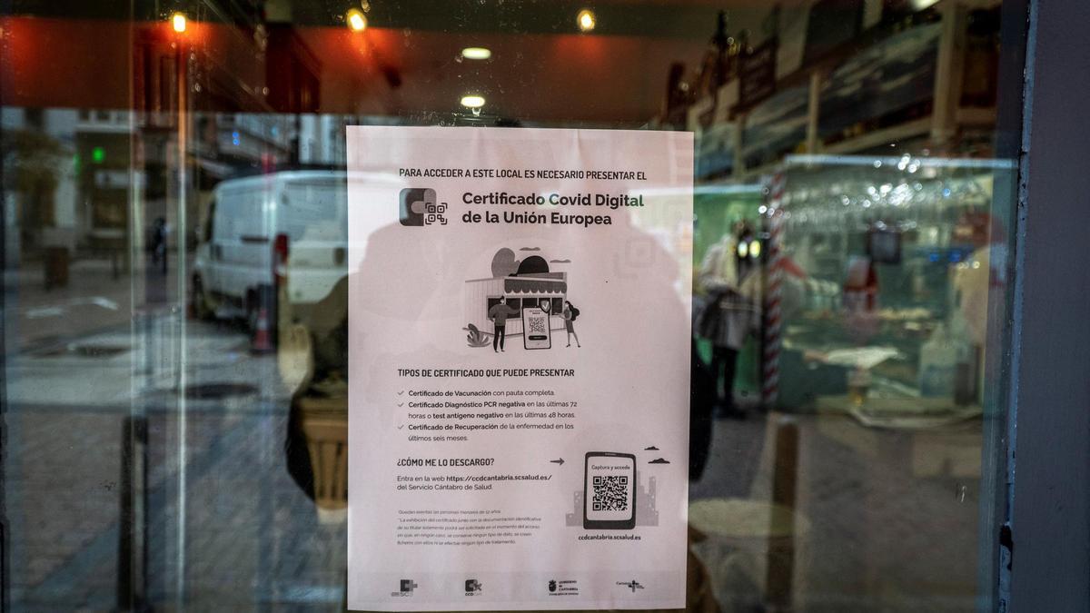 Un cartel indica la obligatoriedad de uso del pasaporte covid en un bar.