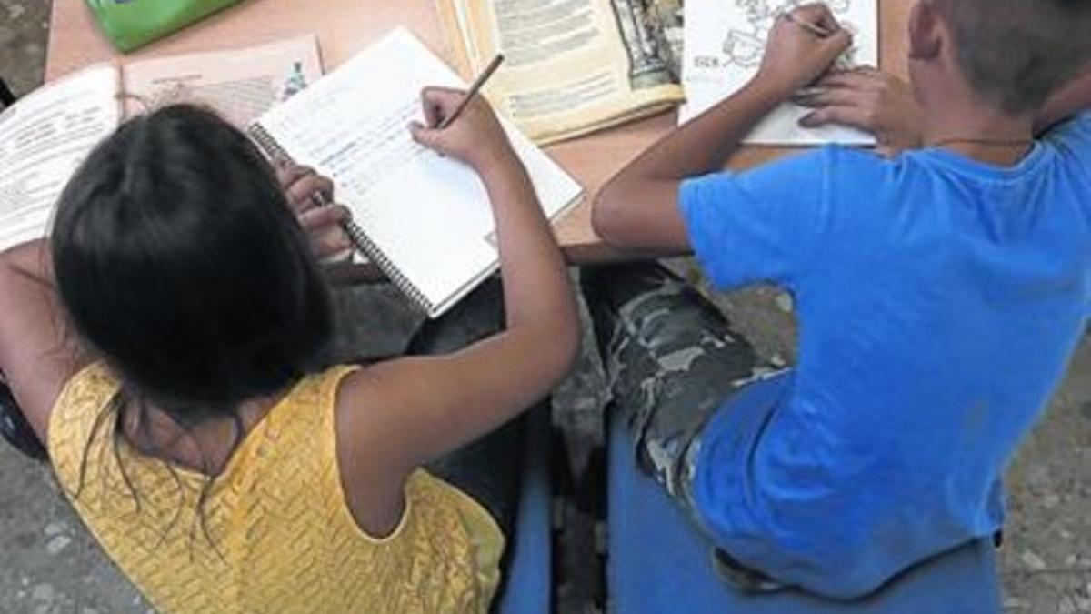 Dos niños hacen los deberes en el centro de la Fundación Adsis en el Carmel, en Barcelona.