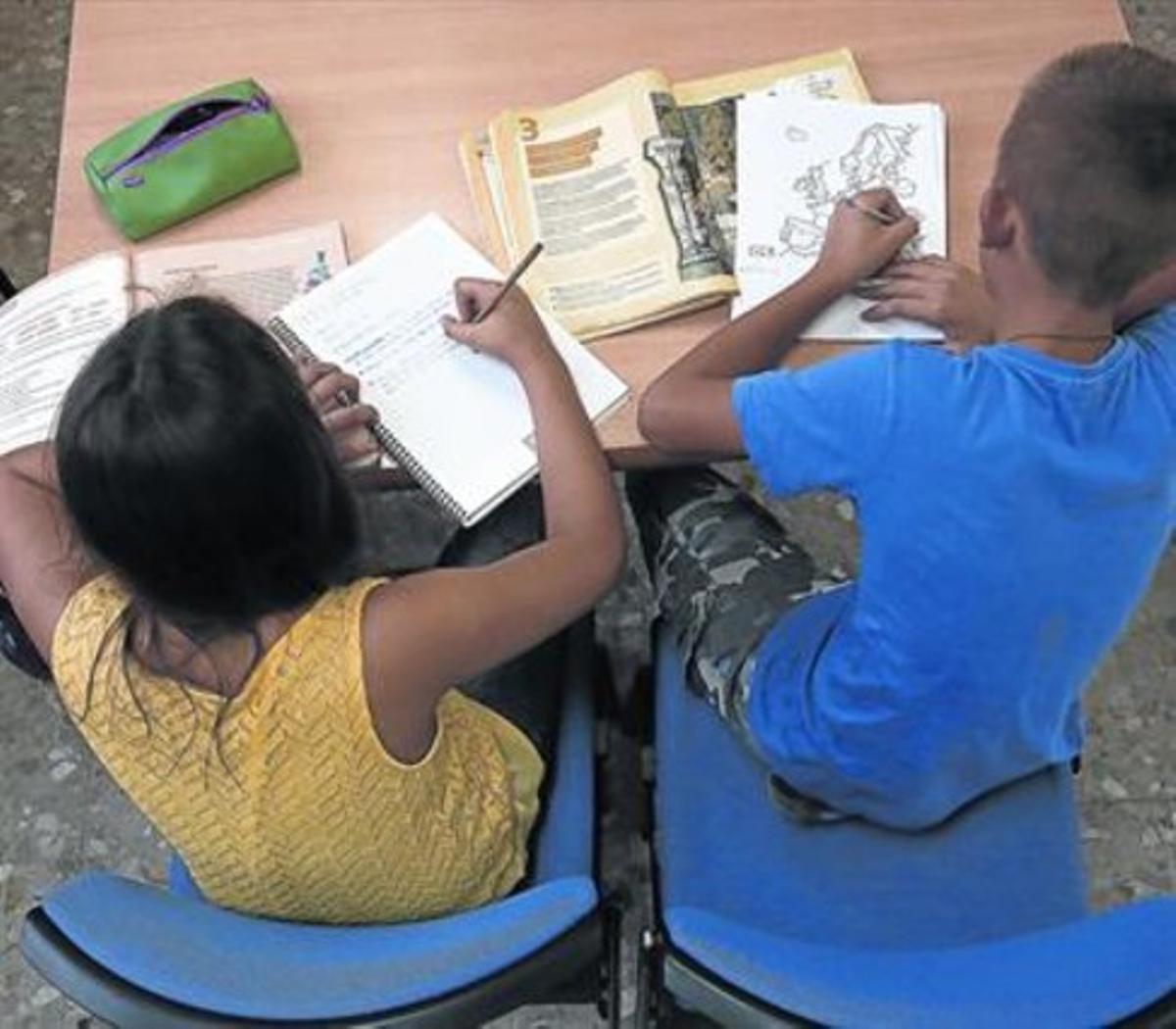 Dos nens fan els deures al centre de la Fundació Adsisal Carmel, a Barcelona.