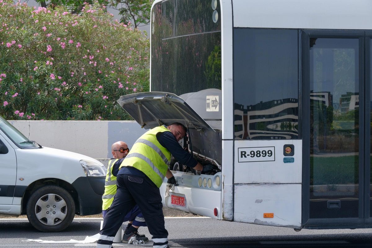 Los mecánicos intentando reparar el autobús averiado