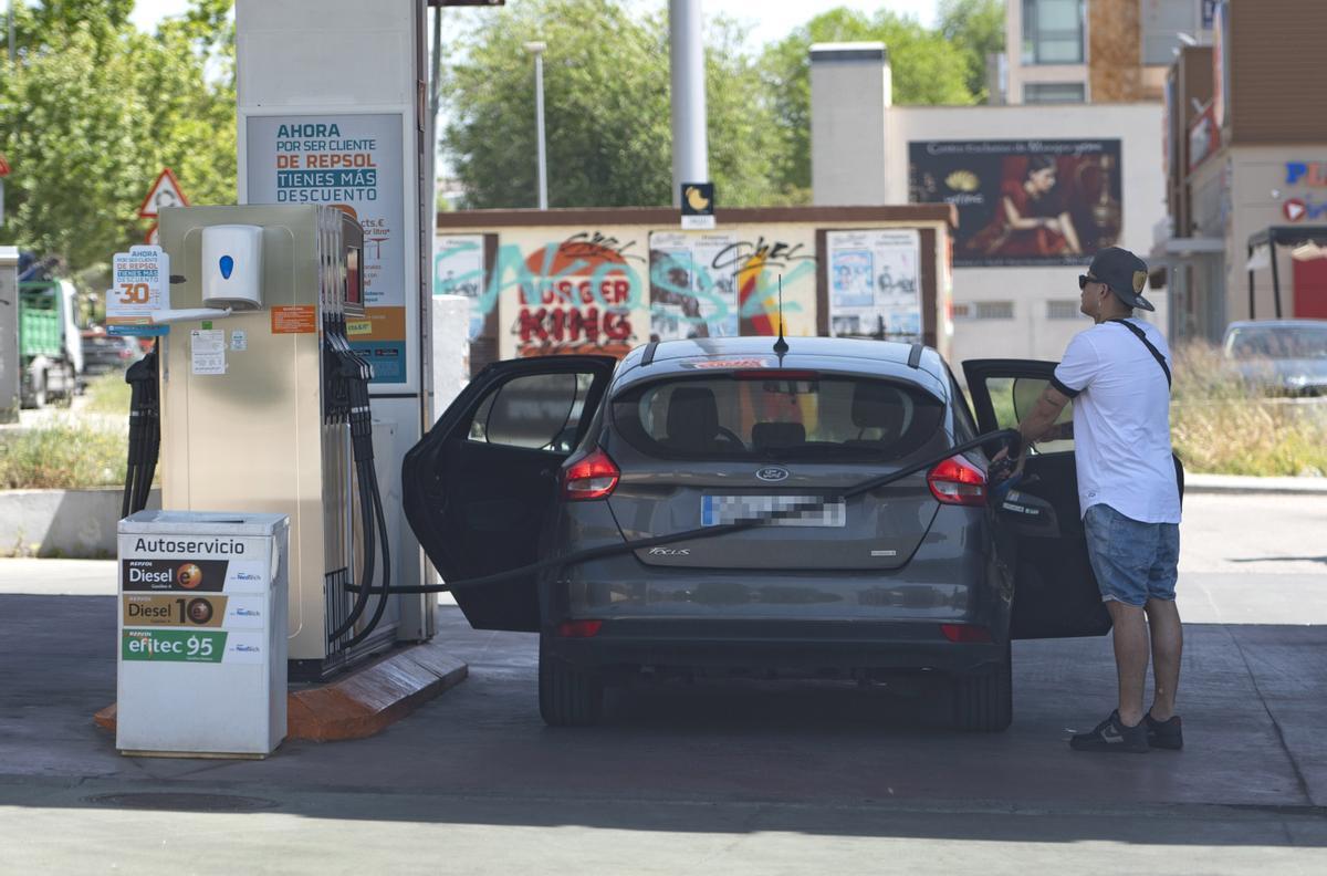 Un hombre reposta en una gasolinera.