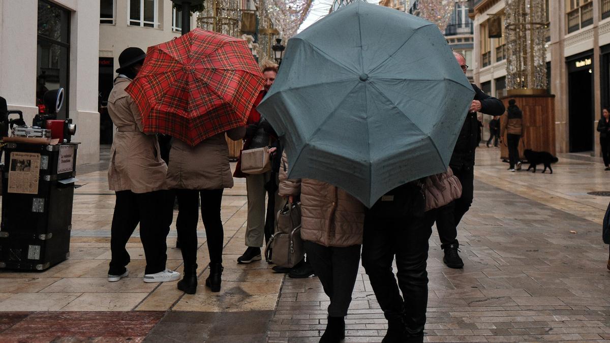Un grupo de personas abre sus paraguas para protegerse de la lluvia