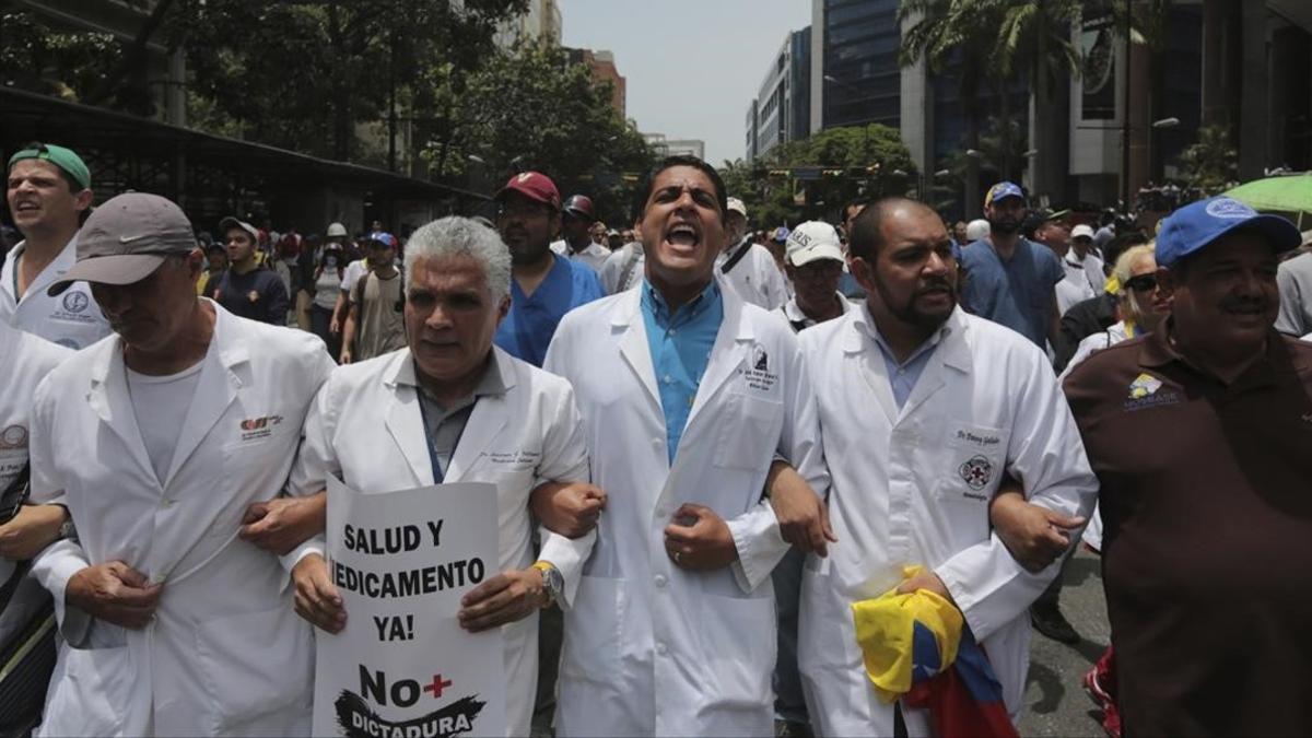 El congresista y doctor José Manuel Olivares grita rodeado de otros profesionales en la marcha de médicos, en Caracas, el 22 de mayo.