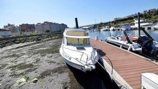 Un barco varado con la marea baja en el puerto deportivo del Lérez debido a los sedimentos. // G. S.