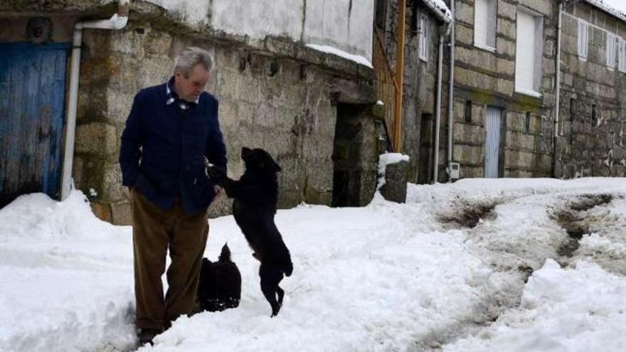 Un hombre, con su perro, en una aldea nevada de Montederramo.  // Brais Lorenzo