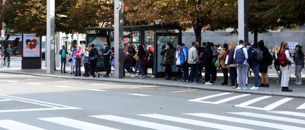 Varios usuarios esperando en una parada de autobús durante la huelga en Zaragoza.