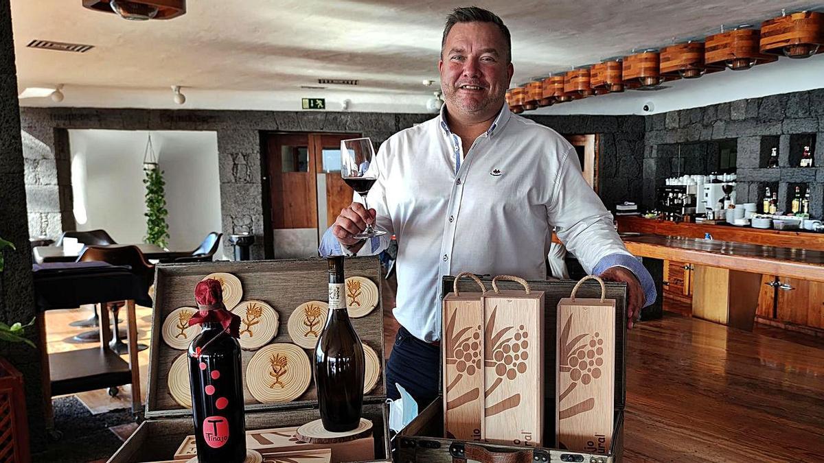 Daniel Lasso, con una muestra de botellas y cajas de la producción de vino de Tinajo.