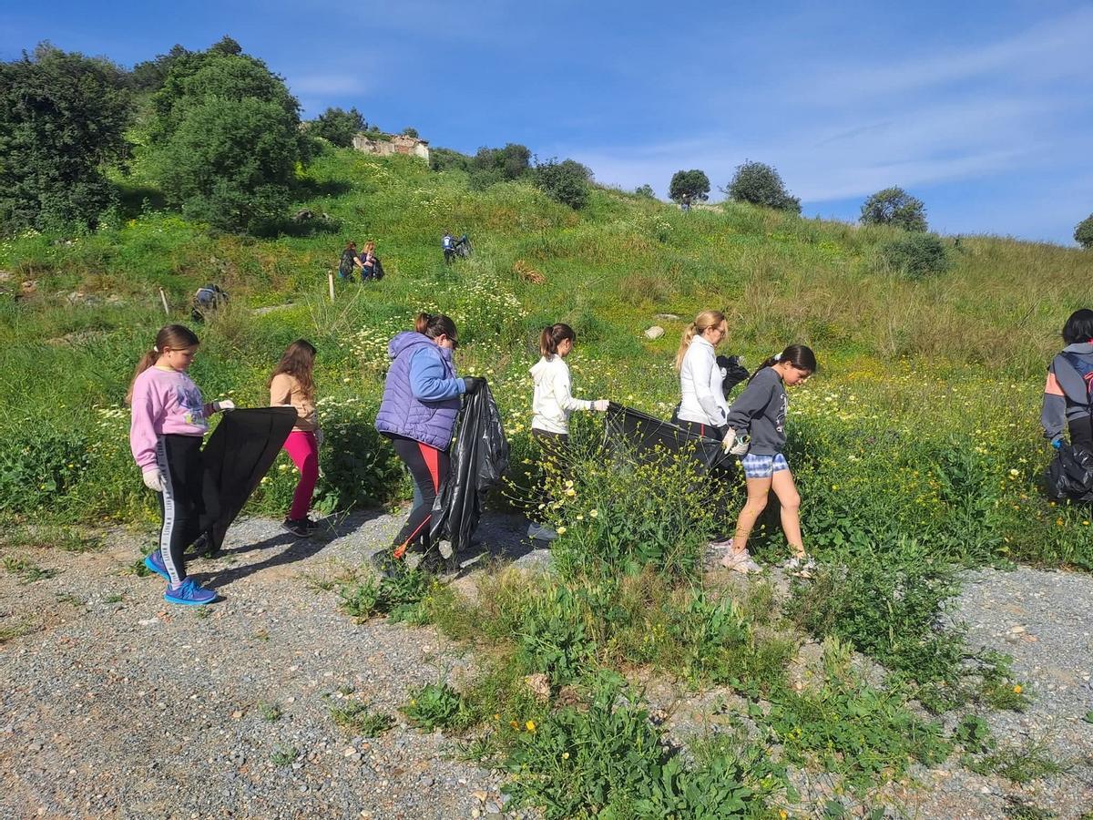 Voluntarios de Delbache Drone, incluidos menores, limpian al pie de la Sierra de Churriana.