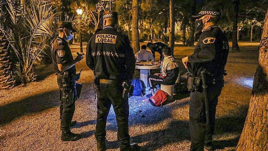 Policías de Elche multando a unos jóvenes por un botellón.