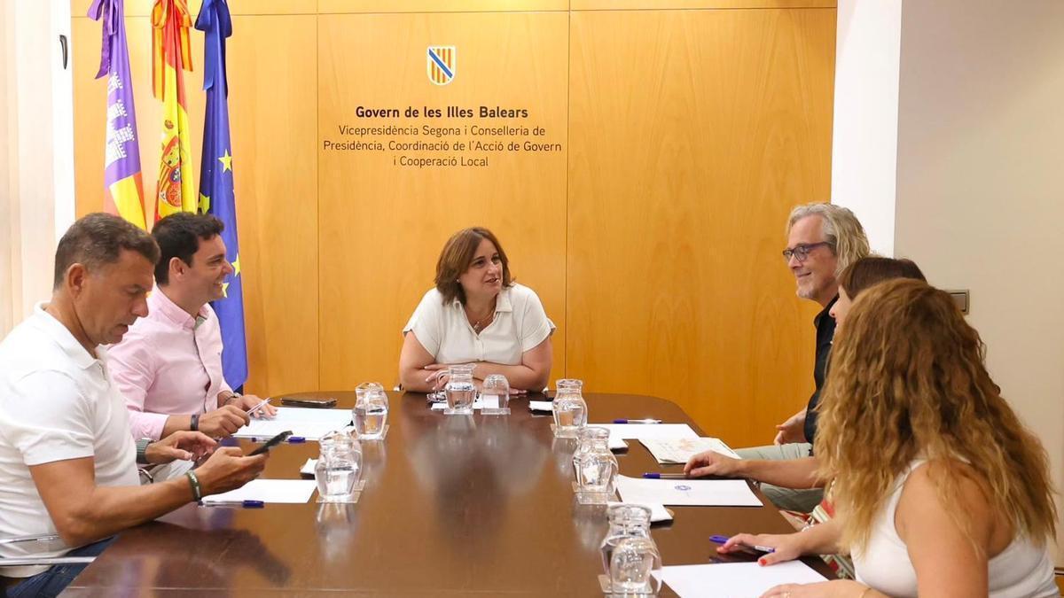 Imagen de la vicepresidenta segunda, Antònia Maria Estarellas, y  el director general de Inmigración y Cooperación al Desarrollo, Manuel Pavón, junto a los representantes de las oenegés.