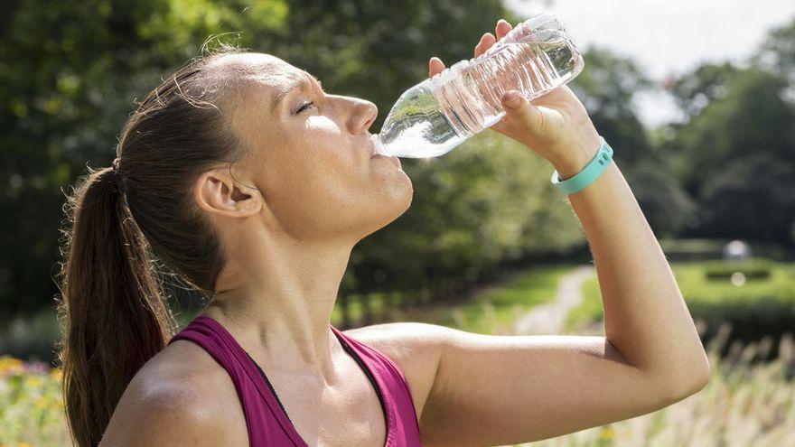 Una chica se refresca con agua en un día de calor.