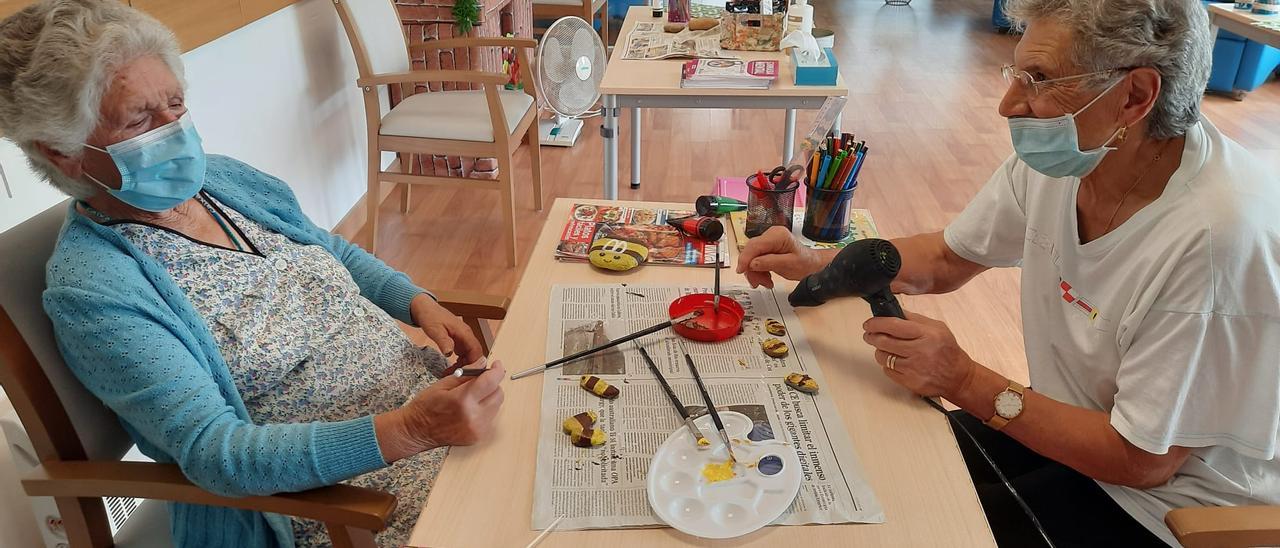 Dos usuarias de la Casa do Maior de Vide, en Castrelo de Miño, realizan manualidades.