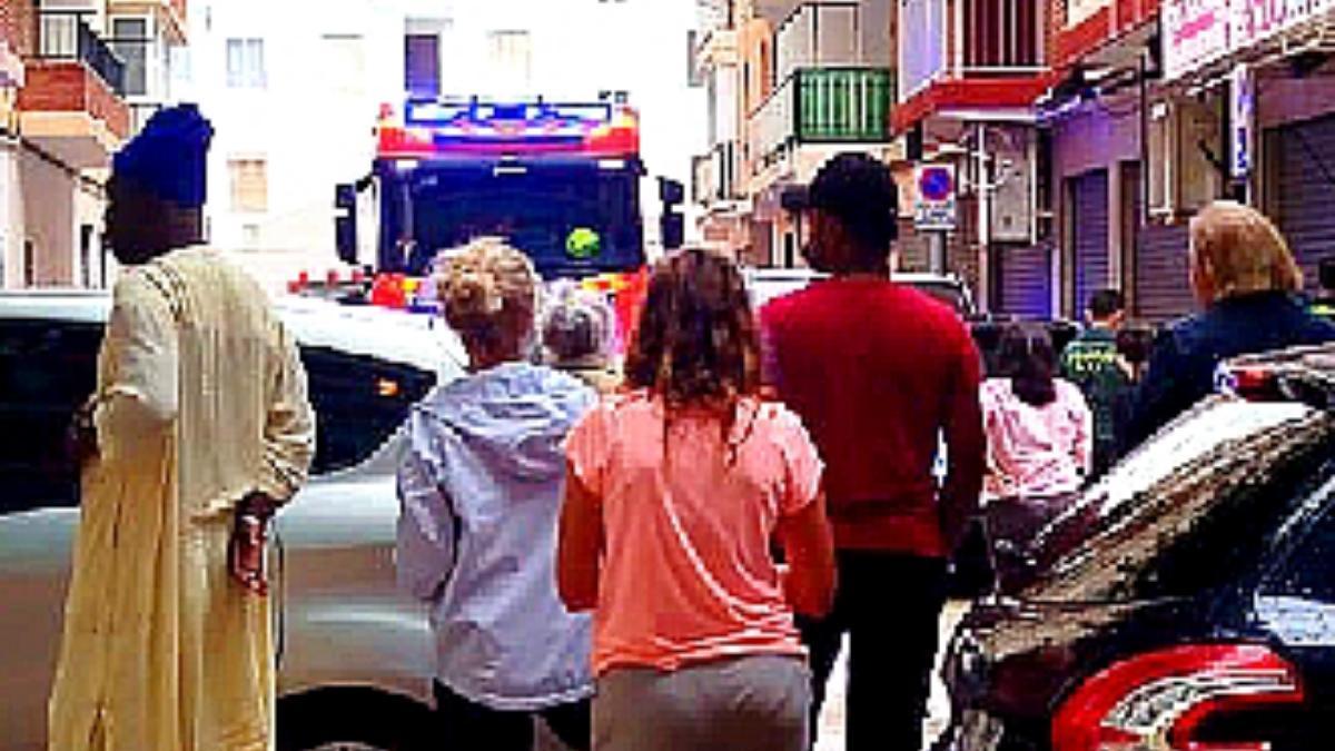 Un grupo de vecinos, frente al camión de bomberos desplazado al edificio afectado.