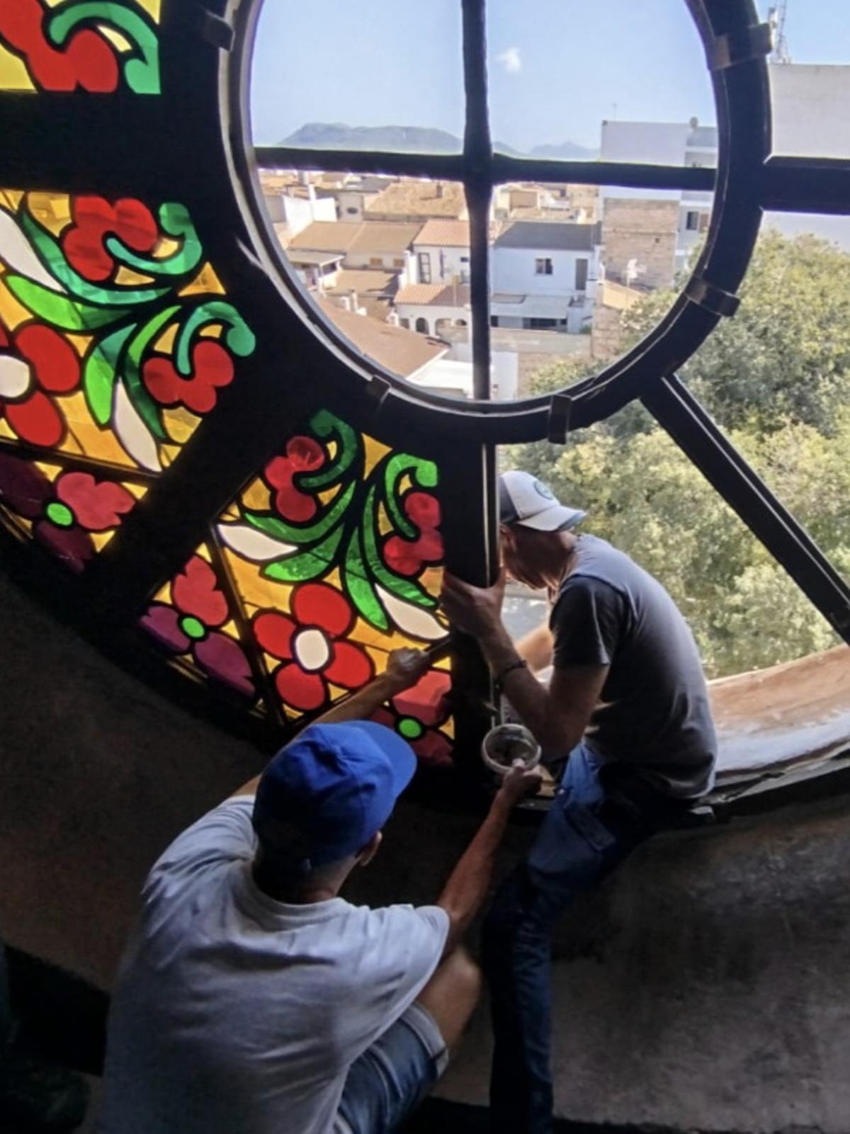 Juan Carlos y su ayudante dan los últimos toques al vitral.