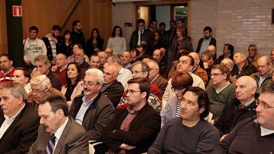 Asistentes al acto, con Aníbal Vázquez, alcalde de Mieres, a la izquierda. A la derecha, un tren pasa por el puente de Parana, diseñado por Eiffel.