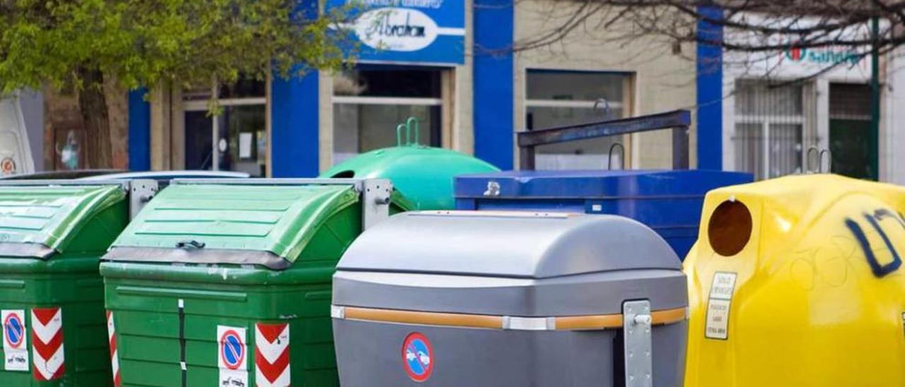 Uno de los contenedores especiales para la recogida selectiva de materia orgánica, en un lineal de depósitos de basura y reciclaje de una calle del Polígono de Pumarín.