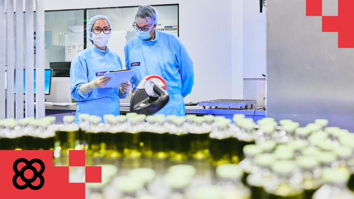 Dos trabajadores de Grifols observan bolsas plasma sanguíneo