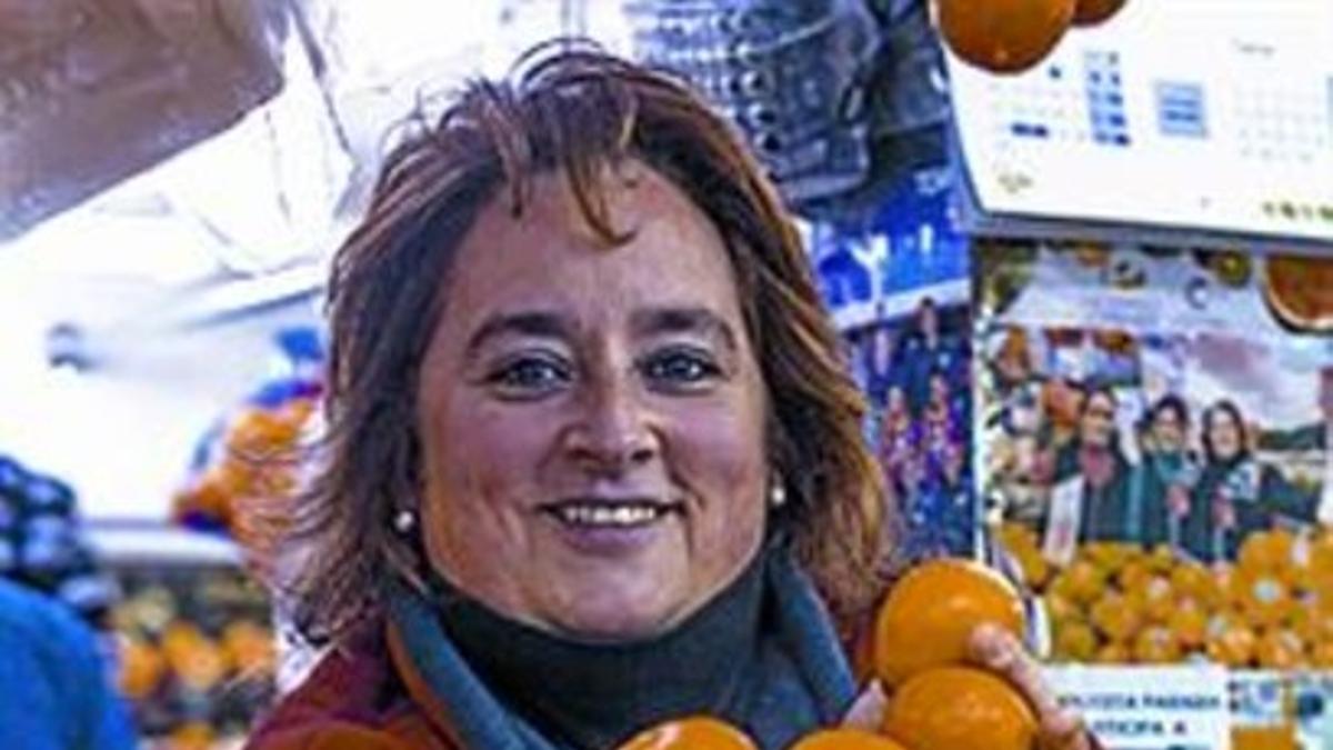 Antònia González muestra unas mandarinas en su parada.