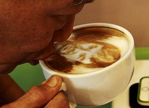 Un hombre bebe una taza de café con una caricatura de Manny Pacquiao