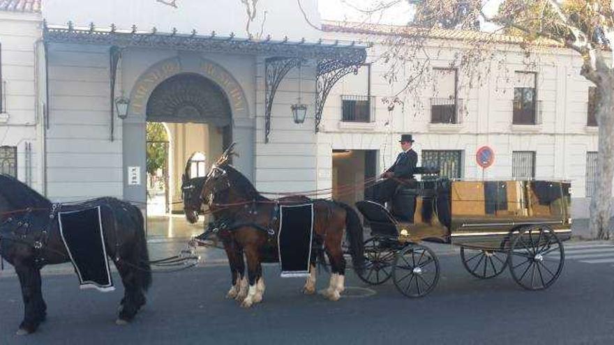 El carruaje utilizado en los funerales con el cochero y lacayo ataviados con la indumentaria propia del siglo XIX.