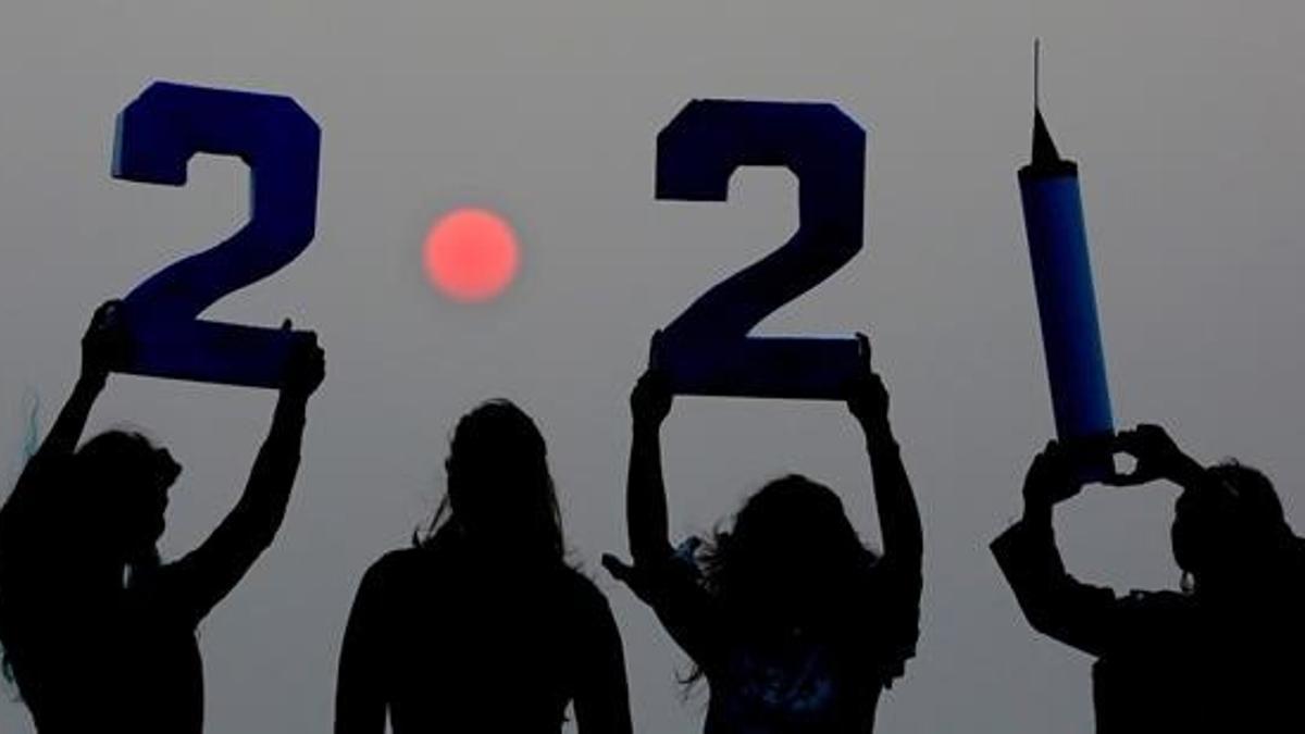 -FOTODELDIA- EA3732  BHOPAL  30 12 2020 - Varias chicas indias con la puesta del sol al fondo  sostienen numeros y una jeringuilla  celebrando la llegada del nuevo ano en Bhopal  India  hoy 30 de Diciembre de 2020  EFE EPA SANJEEV GUPTA