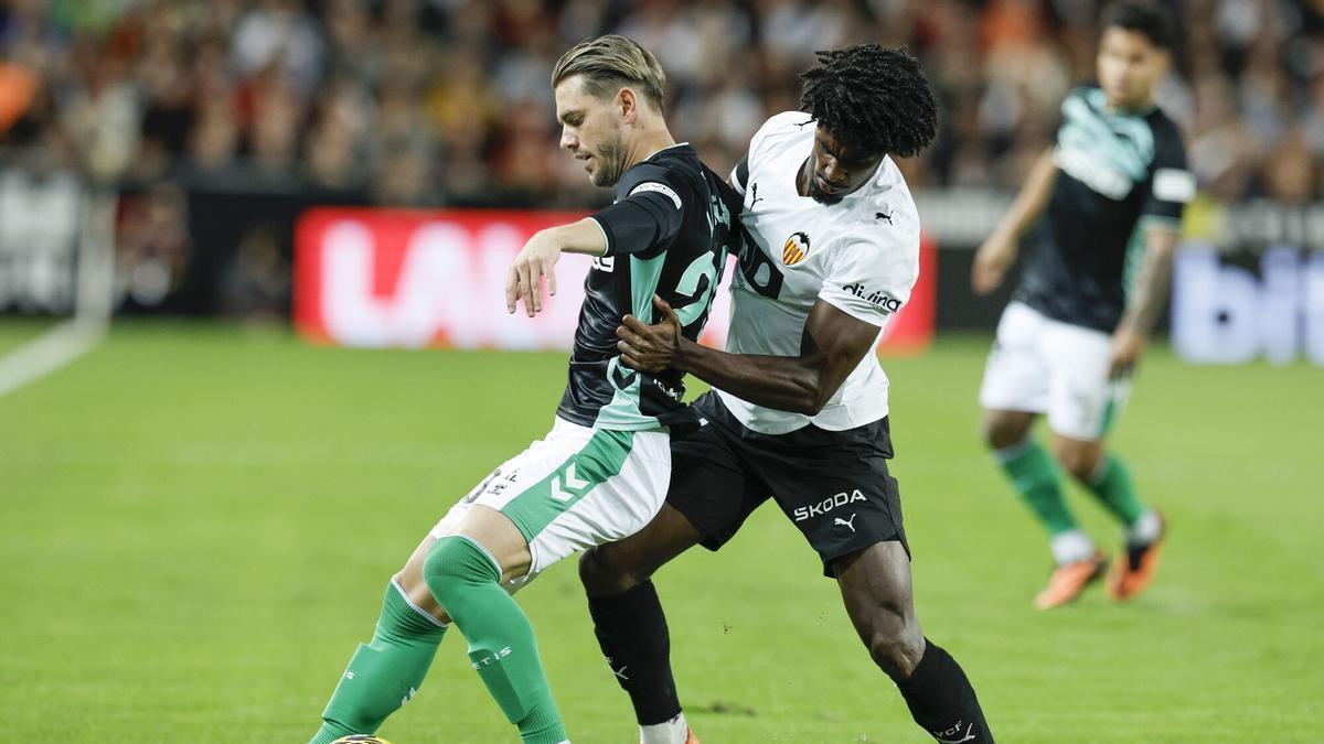 Giovani Lo Celso protege el balón ante Thierry Correia durante el encuentro correspondiente a la jornada 12 de LaLiga EA Sports que disputan Valencia y Betis en el estadio de Mestalla