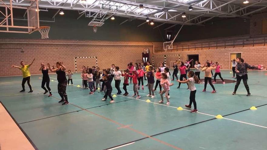 Los pequeños aprenden zumba en el pabellón municipal.