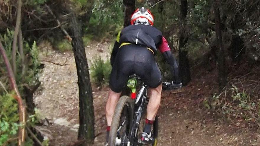 Un ciclista en ple descens per un corriol a la Vall de Sant Daniel.?