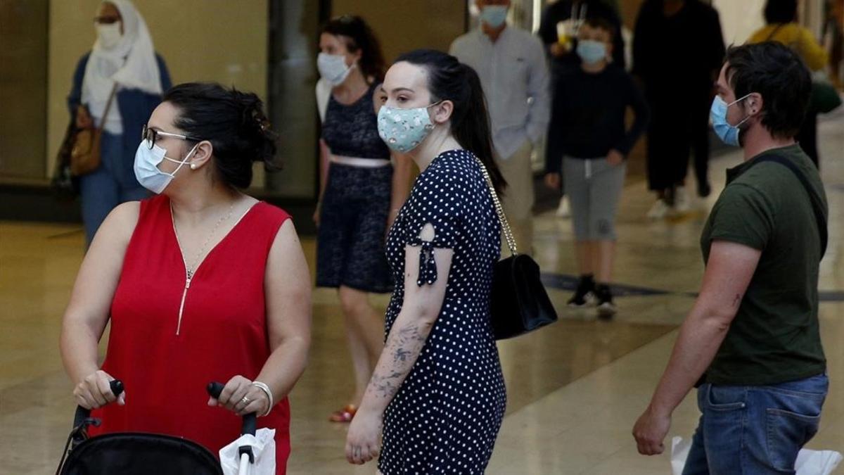 Clientes con marscarillas en un centro comercial de las afueras de París.