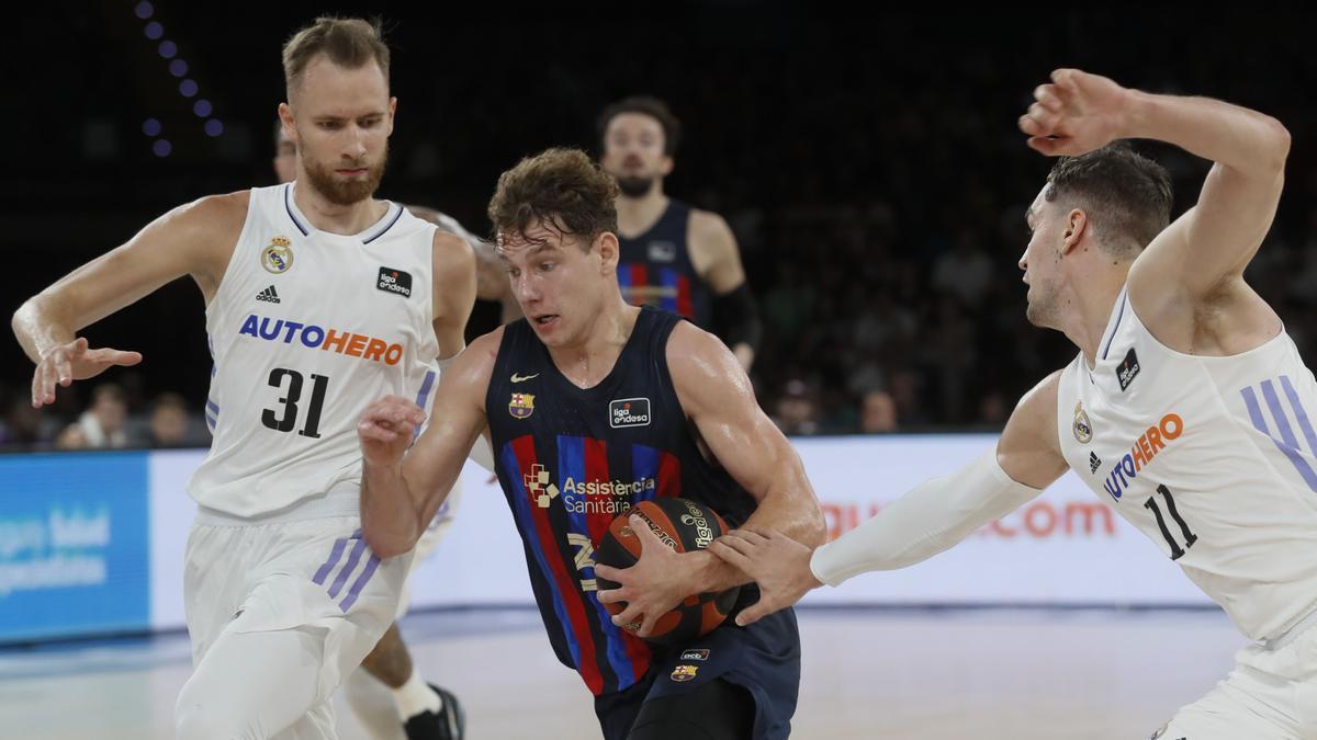 El base lituano Rokas Jokubaitis (c), del Barcelona, penetra ante la defensa del alero bosnio Dzanan Musa (i) y el alero croata Mario Hezonja (d)