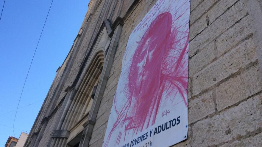 Atornillan un cartelón en la fachada de la iglesia de Benissa