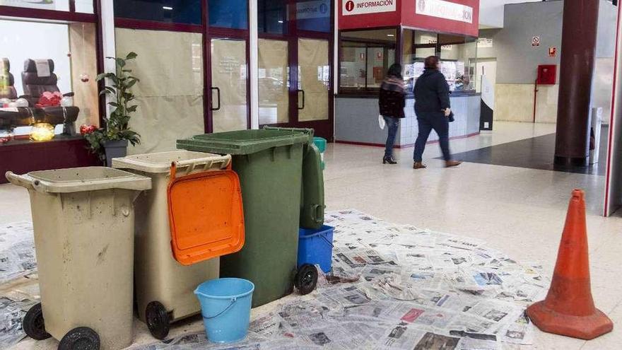 Cubos y contenedores recogen el agua de las goteras en el vestíbulo de la estación de buses. // C. Graña