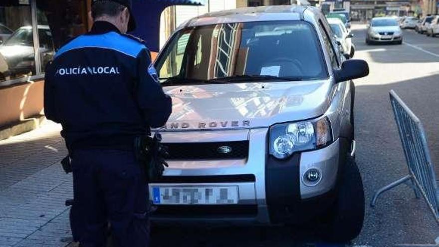 Un policía local de Vilagarcía, multando en zona azul. // Noé Parga