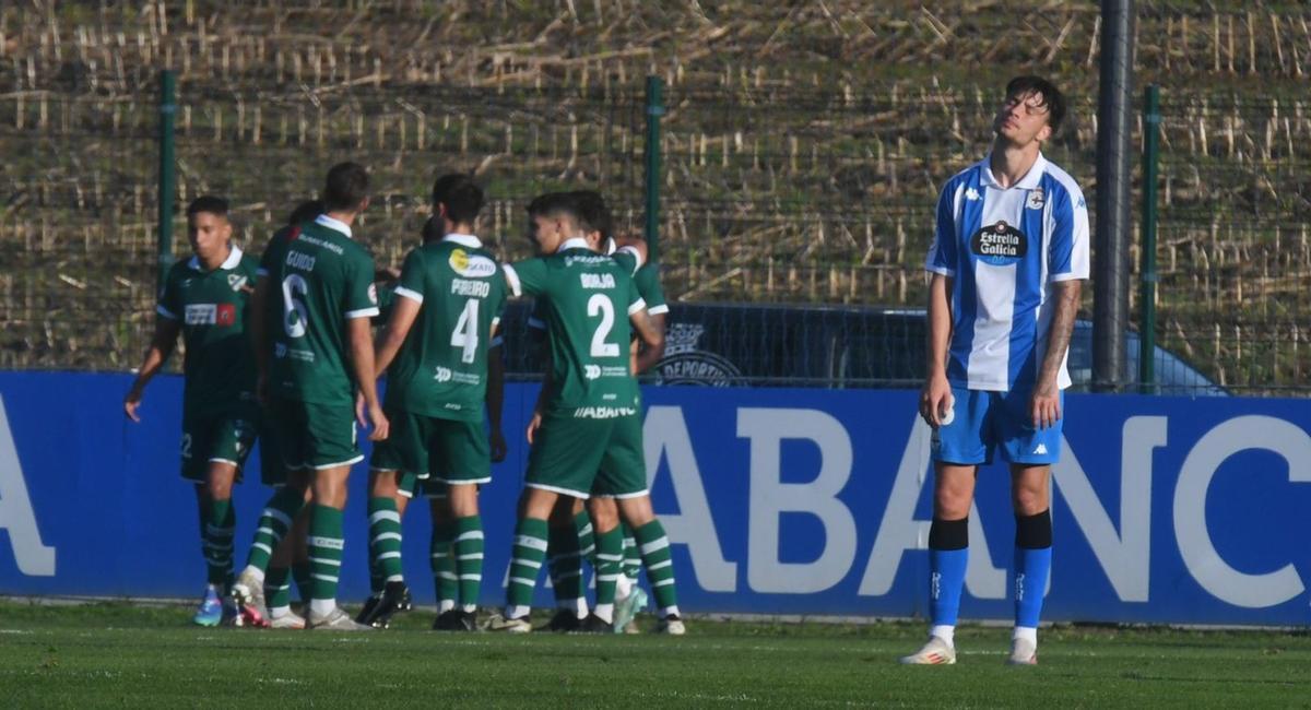 Los jugadores del Coruxo celebran su gol ante la desesperación de un futbolista del Fabril. | La Opinión
