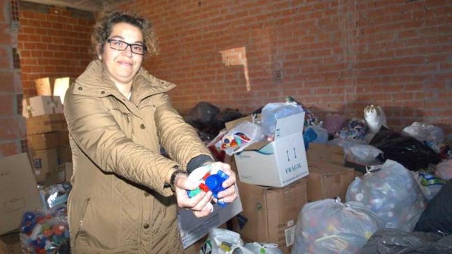 María Isabel Suárez, en el bajo de la Pola donde se guardan los tapones recogidos por los comerciantes.