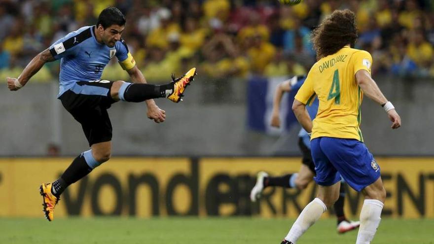 Luis Suárez remata a portería ante la mirada del brasileño David Luiz.