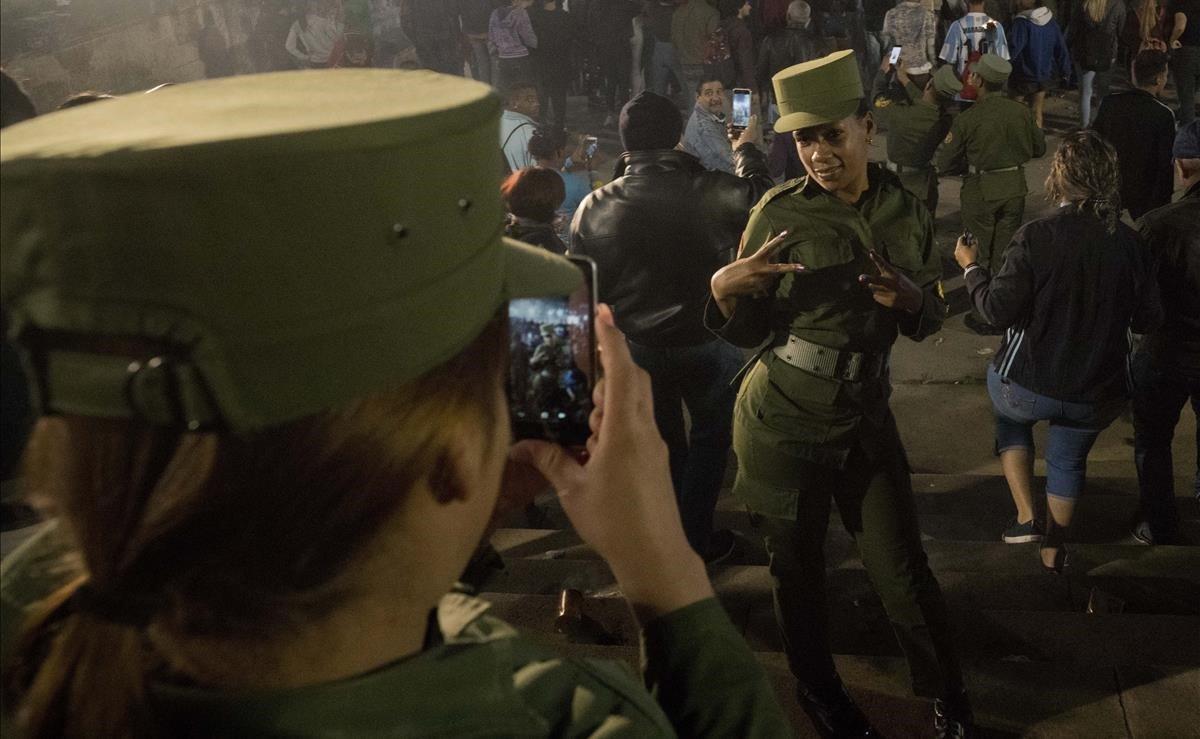 Una soldado cubana posa ante la cámara de su compañera durante una marcha con antorchas para conmemorar el 166 aniversario del nacimiento del héroe de la independencia nacional de Cuba, José Martí, y para rendir homenaje al fallecido líder revolucionario Fidel Castro en La Habana, Cuba.