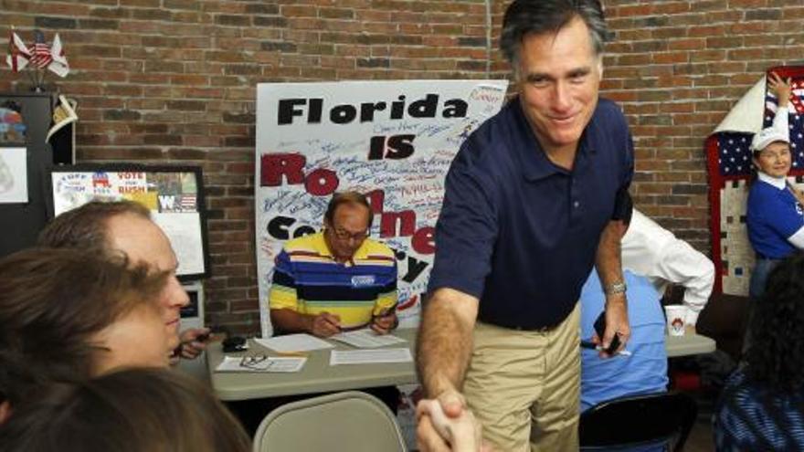 Mitt Romney saluda a un grupo de voluntarios de su campaña, en la sede de Tampa, Florida.