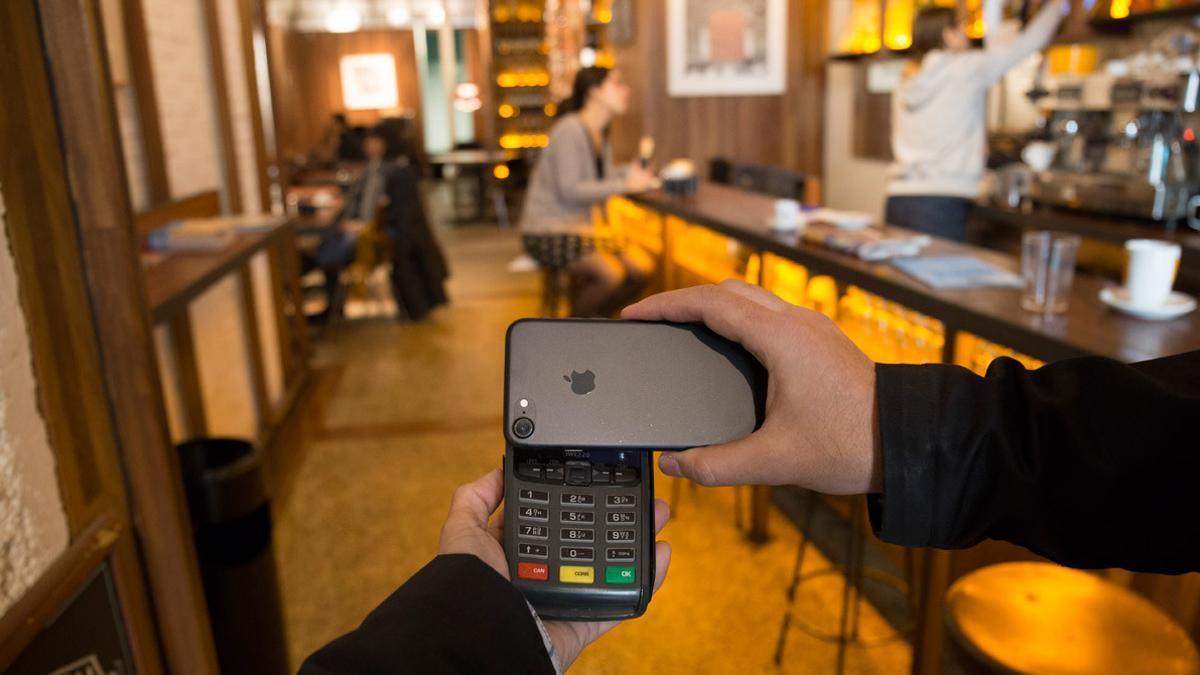 Un cliente paga en un restaurante de Barcelona con su teléfono móvil