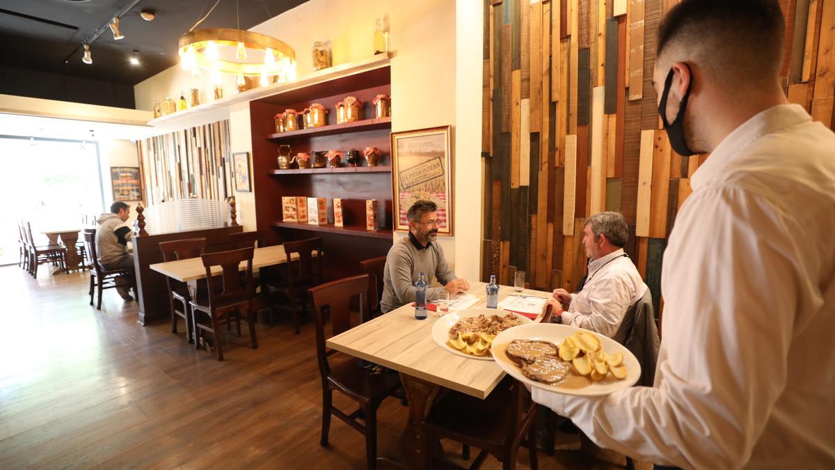 Un camarero sirve en un restaurante de Elche, ayer, con pocos clientes.