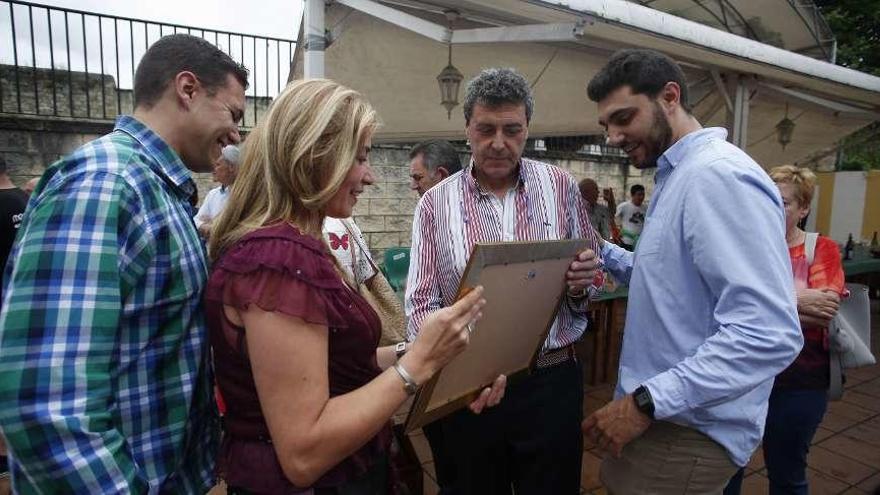 Antonio Guillén y su familia observan el diploma de cofrade de mérito de Gastrónomos del Yumay.