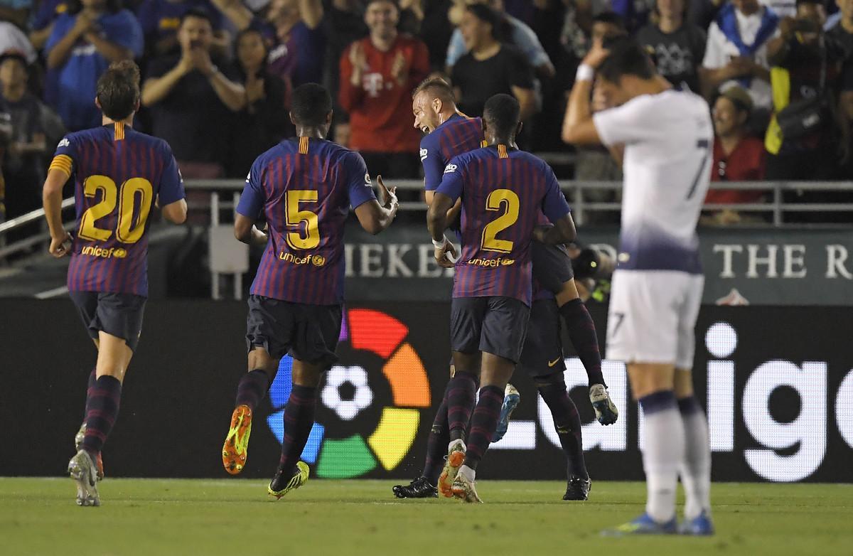 Barcelona midfielder Arthur, center, celebrates his goal with teammates midfielder Sergi Roberto, left, midfielder Marlon Santos, second from left, and defender Nelson Semedo, second from right, as Tottenham forward Son Heung-Min wipes his head during the first half of an International Champions Cup tournament soccer match Saturday, July 28, 2018, in Pasadena, Calif. (AP Photo/Mark J. Terrill)