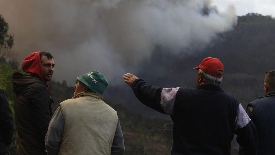 Vecinos de Fontouria, en Valdés, ayer, vigilando la evolución del incendio. | Luisma Murias