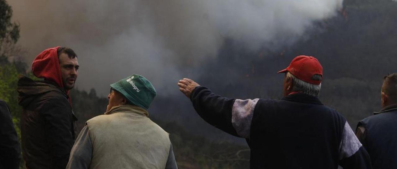 Vecinos de Fontouria, en Valdés, ayer, vigilando la evolución del incendio. | Luisma Murias