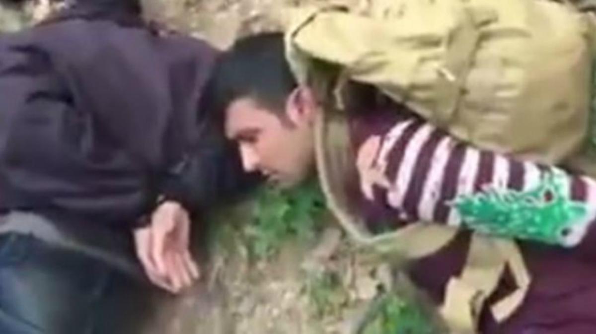 Vídeo en què tres immigrants apareixen lligats de mans i immobilitzats a terra a Bulgària.