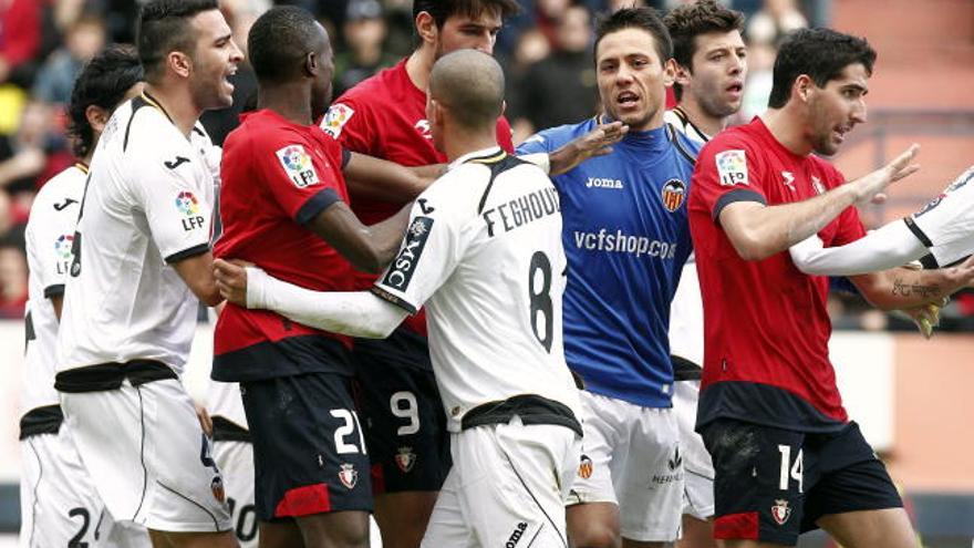 Jugadores de Osasuna y del Valencia discuten en un momento del partido que ambos conjuntos han disputado este mediodía en el Estadio Reyno de Navarra correspondiente a la primera jornada de liga que resultó aplazada por la huelga de los jugadores de futbol.