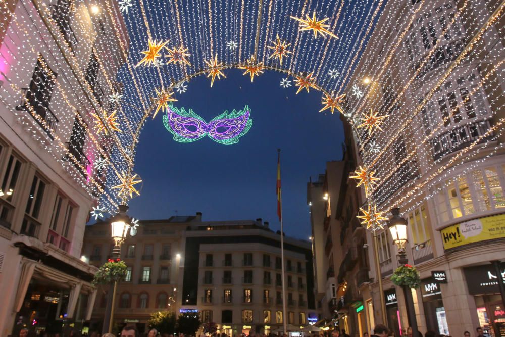 La principal calle del centro de Málaga ya luce los motivos carnavalescos, máscaras y antifaces, con motivo de la Fiesta del Invierno Cálido de la ciudad