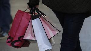 Una mujer, de compras, con unas bolsas.