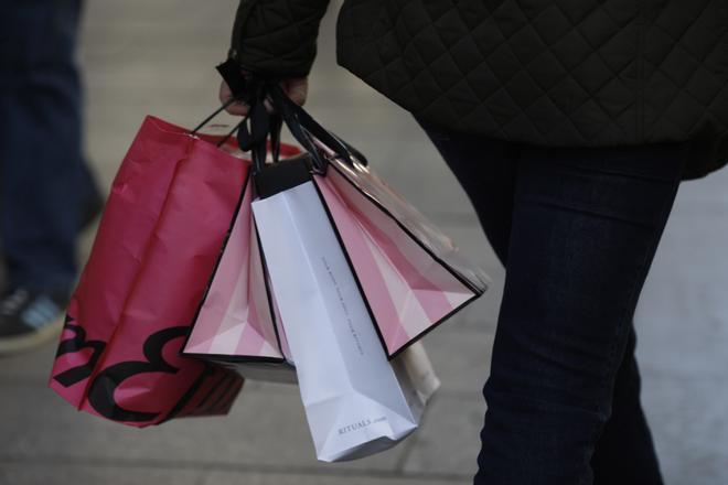 Una mujer, de compras, con unas bolsas.